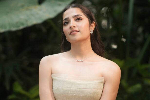 Rukmini Vasanth wearing an ivory Montsand tea-length gown against lush greenery