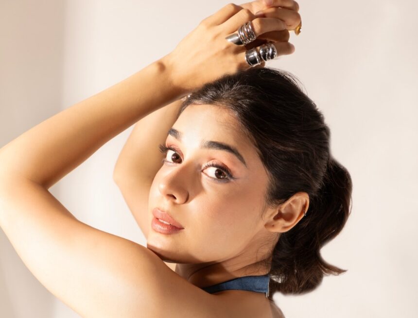 Eisha Singh wearing a pearl-embellished denim top and plaid mini skirt in a Y2K-inspired fashion shoot