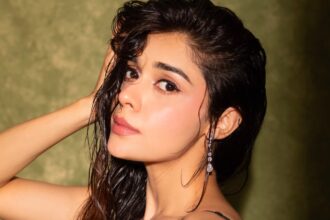 Eisha Singh wearing a crystal-embellished black satin gown in a cinematic photoshoot