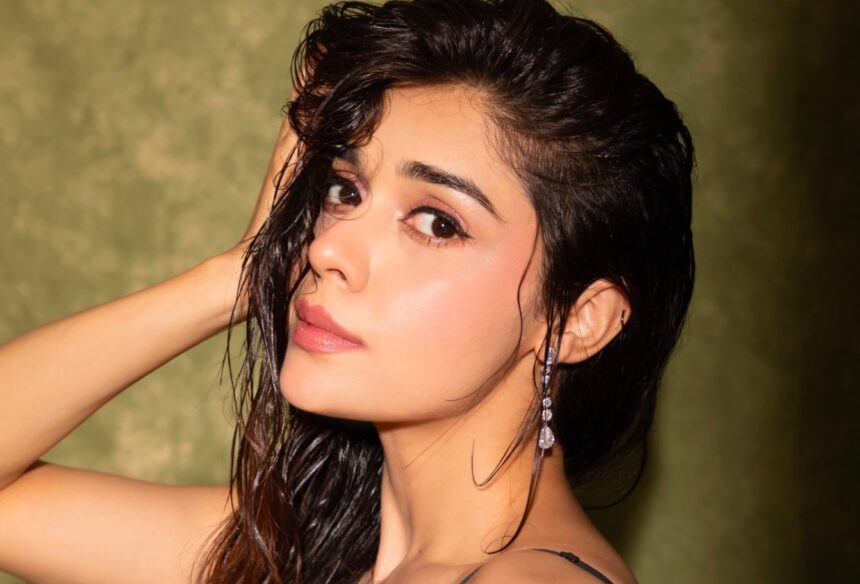 Eisha Singh wearing a crystal-embellished black satin gown in a cinematic photoshoot
