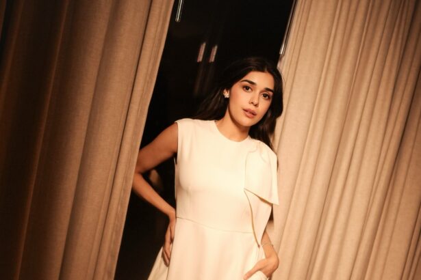 Rukmini Vasanth wearing an ivory draped dress in warm ambient lighting