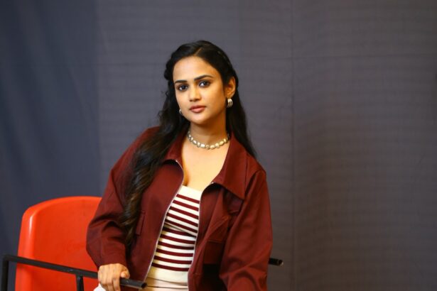 Ariyana Glory poses in a rust-maroon cropped jacket and wide-leg trousers
