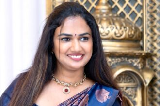 Ariyana Glory in a navy silk saree with copper peacock motifs and ruby jewellery