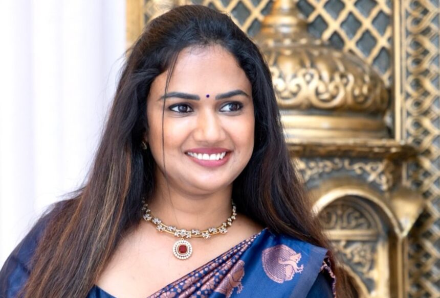 Ariyana Glory in a navy silk saree with copper peacock motifs and ruby jewellery