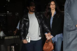 Aamir Khan holds Gauri Spratt close as they walk hand-in-hand at Mumbai Airport.