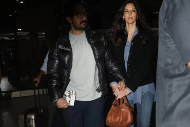 Aamir Khan holds Gauri Spratt close as they walk hand-in-hand at Mumbai Airport.