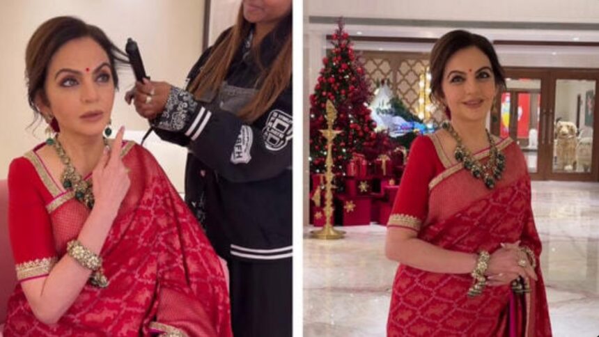 Nita Ambani wearing a red Swades saree and emerald necklace, giving hairstyling instructions