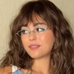 Woman showcasing the trendy Allie-Cat Cut hairstyle with textured layers and fringe