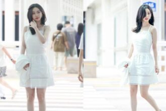 aespa member Karina wearing a white dress at the airport before changing into a casual travel look