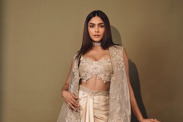 Mrunal Thakur wearing an ivory couture ensemble with an embellished corset, flowing embroidered cape and satin draped skirt.