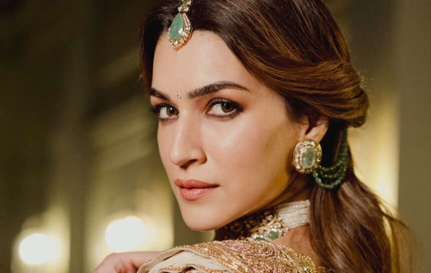 Kriti Sanon wearing an ivory-and-gold Manish Malhotra couture ensemble with emerald jewellery.