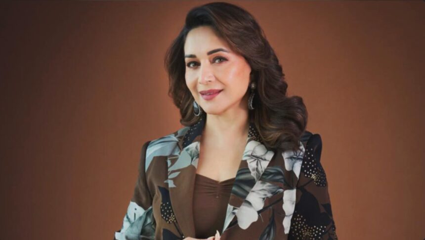 Madhuri Dixit performing ring hanging knee raises during a fitness workout
