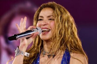 Shakira speaking at a public event while discussing confidence and self-expression