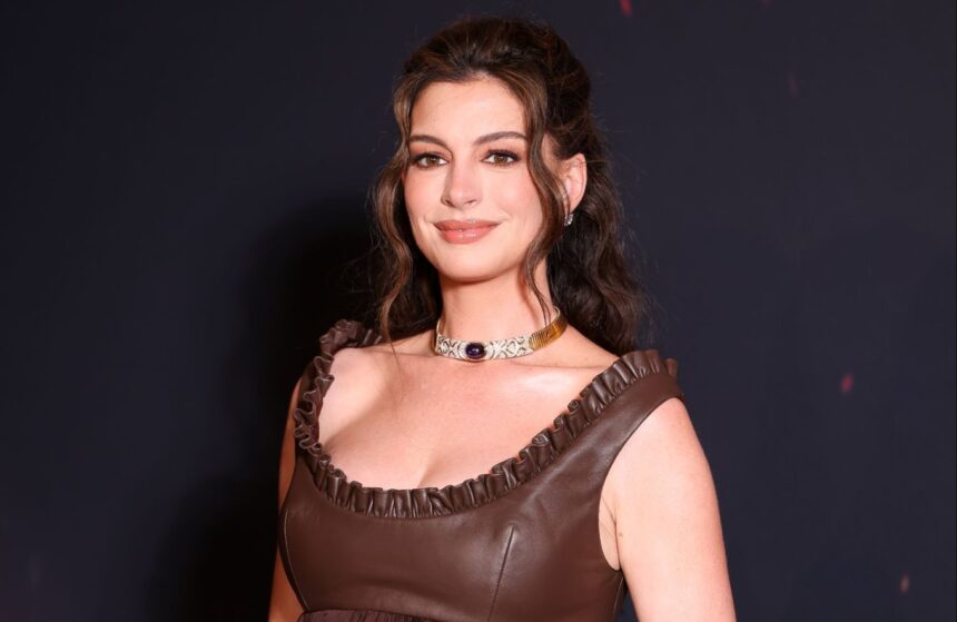 Anne Hathaway attends a red carpet event while discussing her pregnancy journey