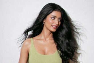 Minimalist fashion photoshoot featuring a soft lime-green dress with natural beauty styling.