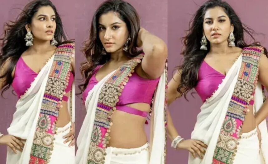Vishnu Priya wearing a white saree with a sleeveless pink blouse.