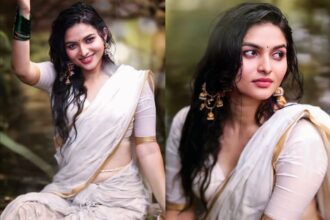 Kayadu Lohar wearing a white Kasavu saree with gold border during a monsoon-themed outdoor photoshoot.