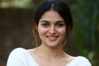 Hunterfly 026 08 07 163449 Kayadu Lohar wearing an off-white knitted sweater and blush pink pleated skirt in a casual outdoor portrait.