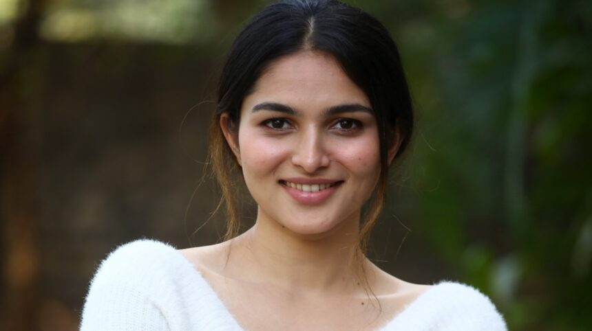Hunterfly 026 08 07 163449 Kayadu Lohar wearing an off-white knitted sweater and blush pink pleated skirt in a casual outdoor portrait.