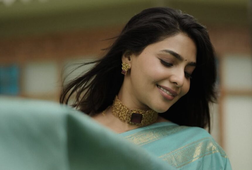 Hunterfly 026 08 07 194846 Aishwarya Lekshmi wearing a powder-blue silk saree with antique gold jewellery during an outdoor fashion photoshoot.
