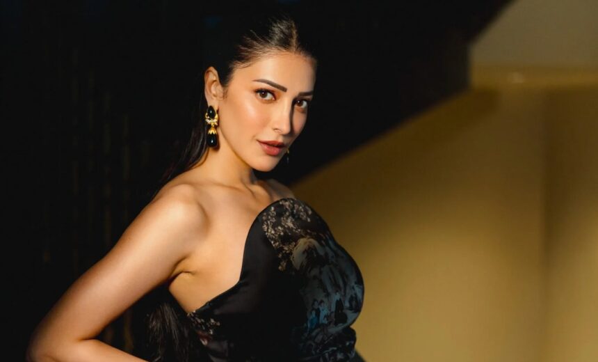 Shruti Haasan wearing a dark satin printed dress with statement earrings