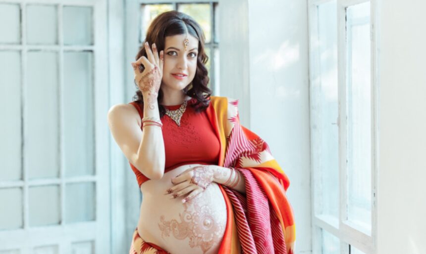 Pregnant woman looking at a tattoo design before making a decision.