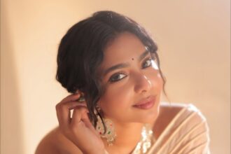 Aishwarya Lekshmi wearing an off-white festive outfit with oxidised jewellery and jasmine flowers during an Onam-themed photoshoot.