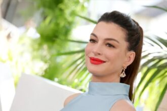 Anne Hathaway shows her baby bump in an ice-blue top and low-rise jeans at The End of Oak Street premiere