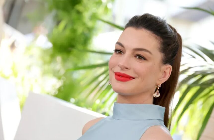 Anne Hathaway shows her baby bump in an ice-blue top and low-rise jeans at The End of Oak Street premiere