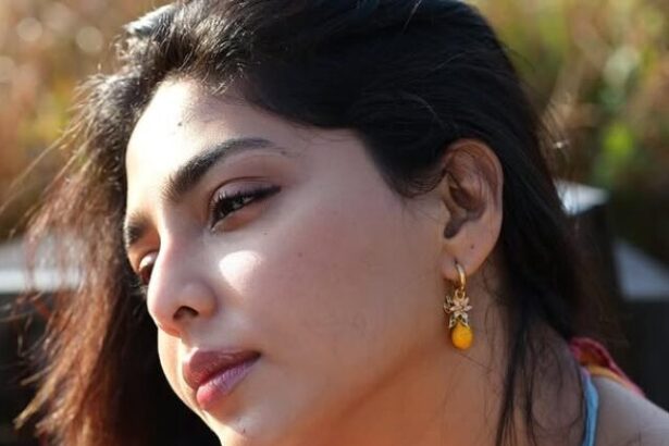 Hunterfly cropped sdfsdf Aishwarya Lekshmi wearing a vibrant floral outfit during a golden-hour outdoor photoshoot in a lush green field.