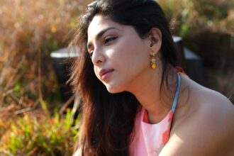 Hunterfly sdfsdf Aishwarya Lekshmi wearing a vibrant floral outfit during a golden-hour outdoor photoshoot in a lush green field.