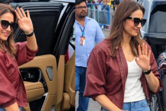 Trisha Krishnan wearing a maroon bomber jacket and light-wash jeans at Silverstone