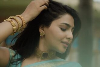 Aishwarya Lekshmi wearing a turquoise saree with traditional gold jewellery