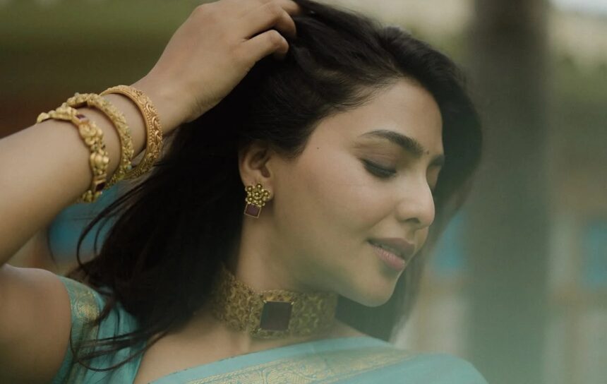 Aishwarya Lekshmi wearing a turquoise saree with traditional gold jewellery