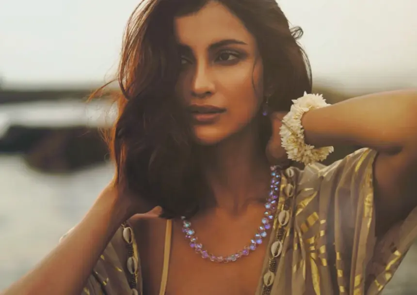 Diksha Singh poses in a gold-patterned kaftan over beachwear in coastal photographs.
